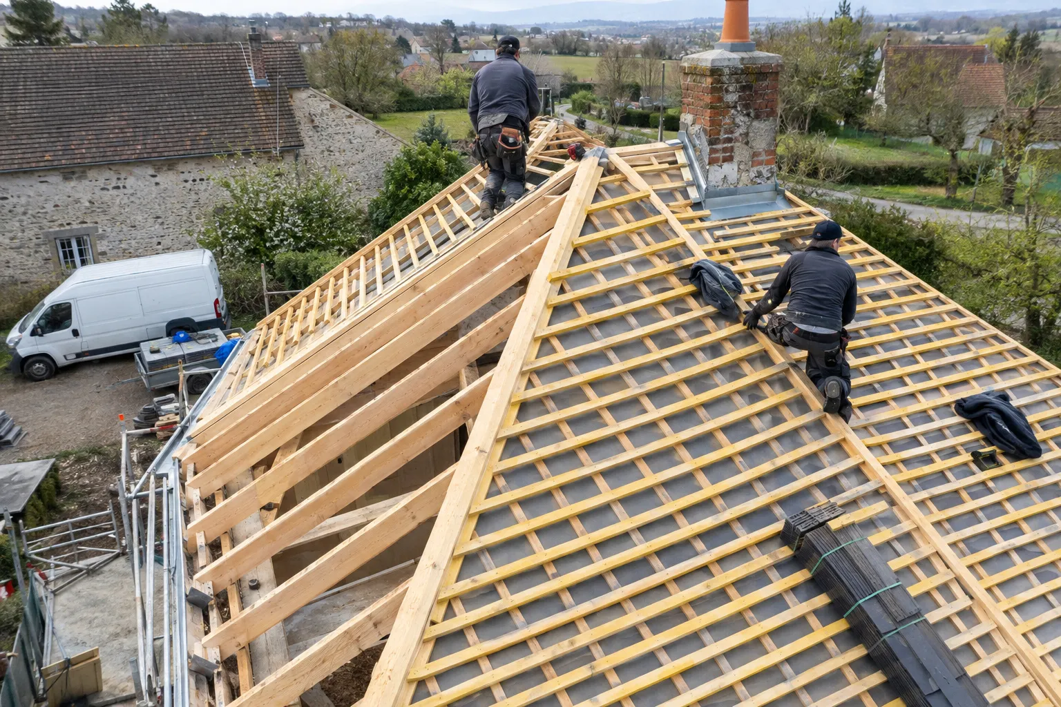 Une charpente neuve et ses liteaux posés avant la couverture, maison en rénovation vue d’en haut.